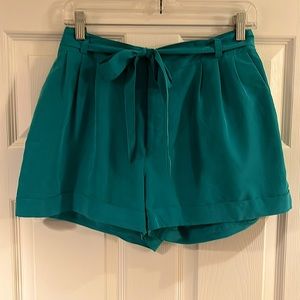 H&M teal shorts size 10 with front bow tie, button, zip and clip.
